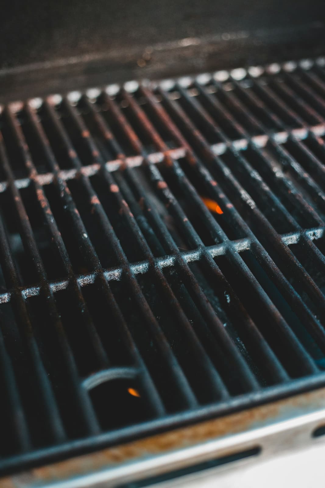Clean cast iron grates inside an open gas grill.