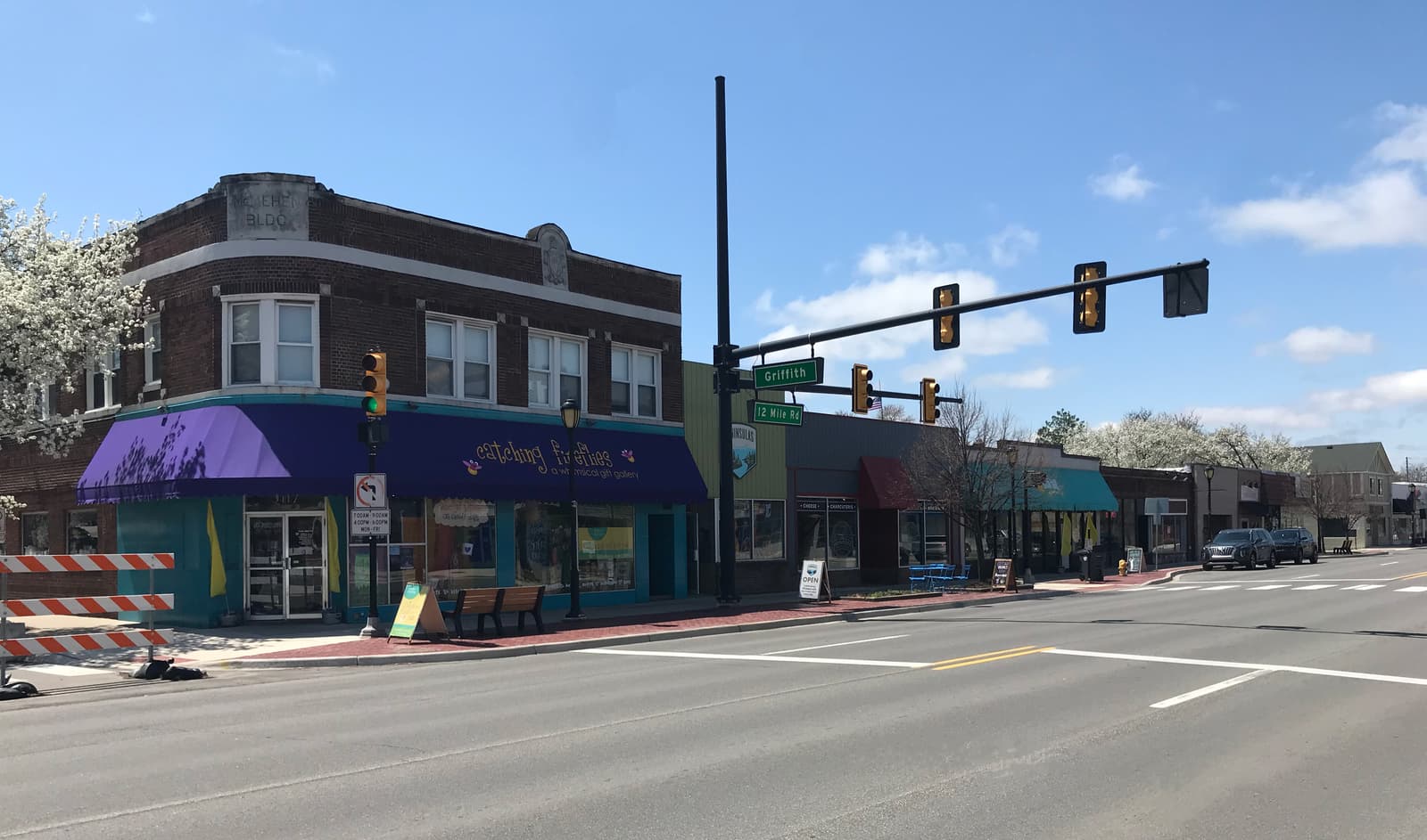 Storefronts along 12 Mile Road in downtown Berkley, Michigan, under a clear sky.