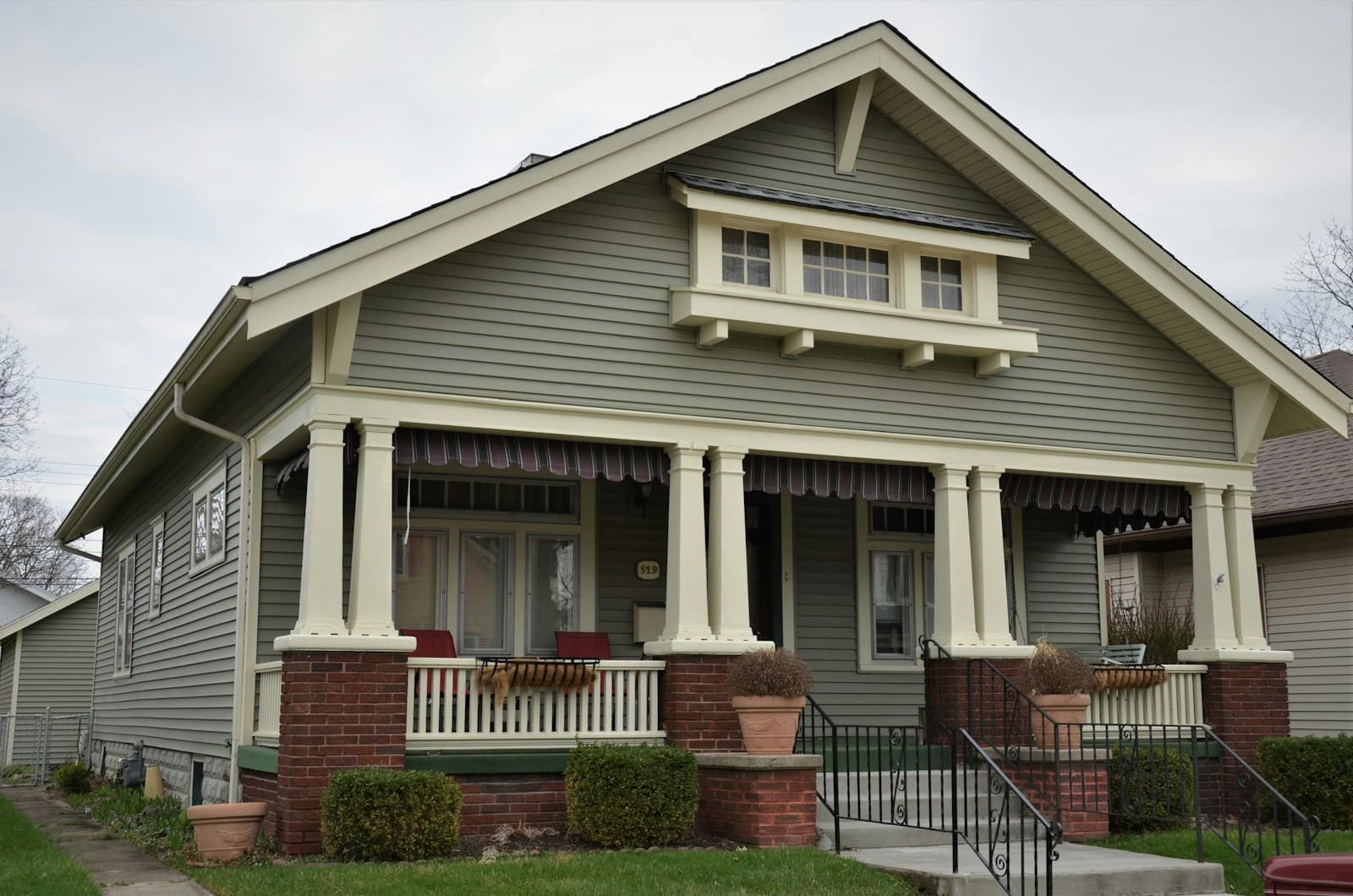 A craftsman bungalow with a deep front porch, tapered columns and brick piers.