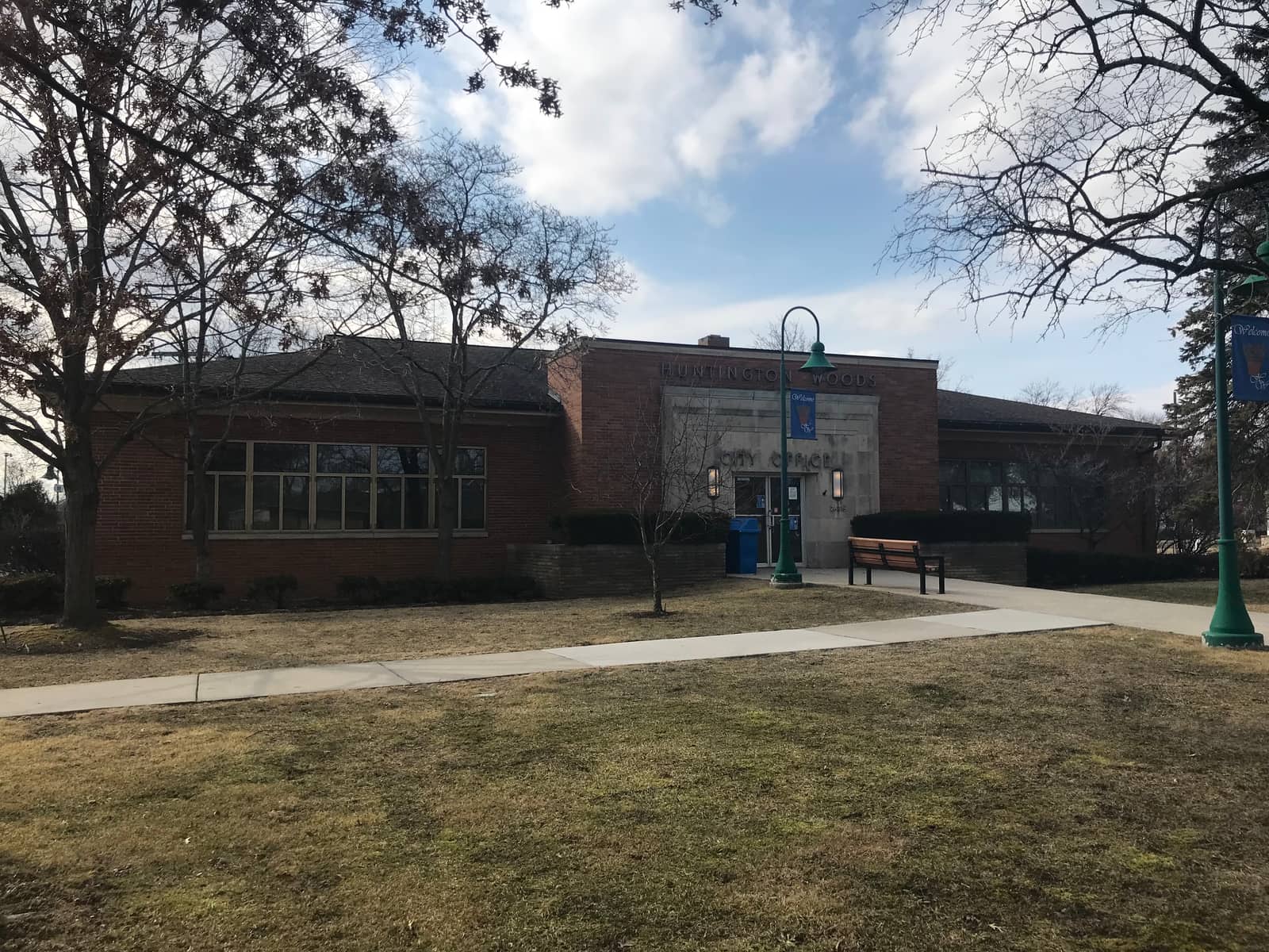 The Huntington Woods city office, a low brick building set back on a lawn.