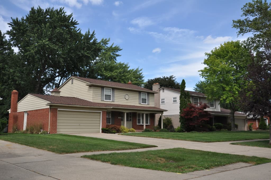 A two-story house with a brick lower floor and an attached garage in the Lathrup Village historic district, Michigan.