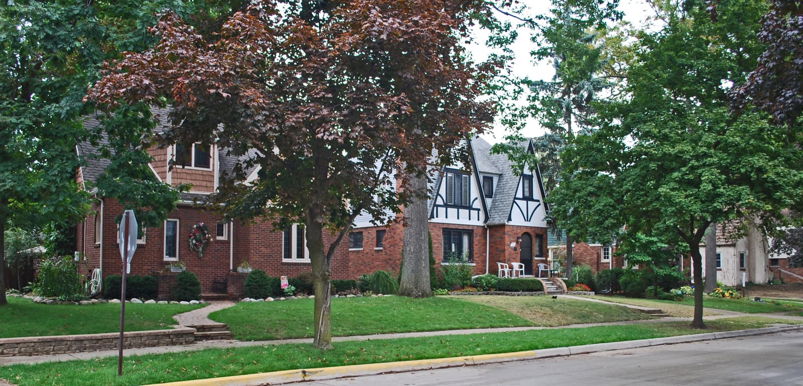 Brick Tudor homes behind wide lawns in the Pleasant Ridge East historic district, Michigan.